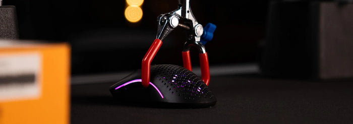 Model O 2 Gaming Mouse being tested in a lab. It has a red claw on it, which is testing its accuracy.