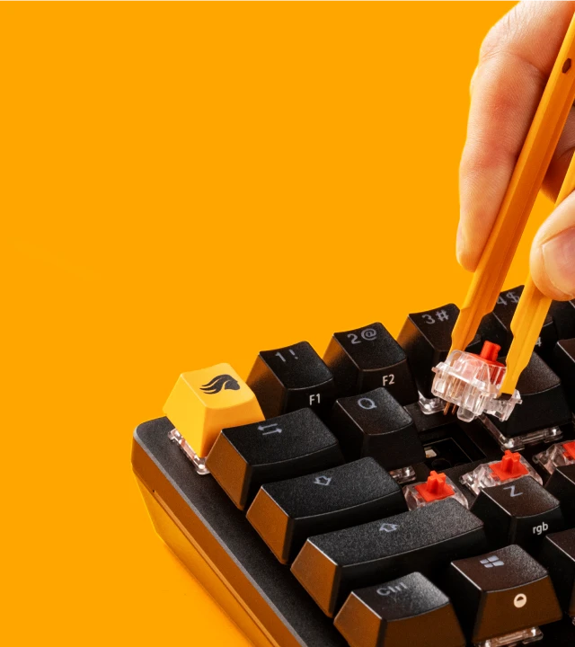 Hand using a switch puller to remove Glorious Fox Switches from a GMMK 3 keyboard
