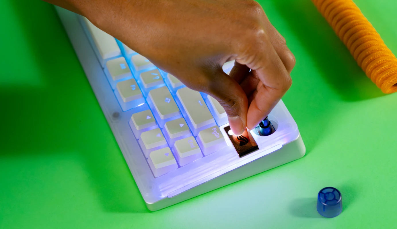 Badge being swapped out on a white GMMK 3 keyboard