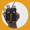 View of the underside of a Model D 2 Wired mouse in Black being moved by a hand gripping the mouse